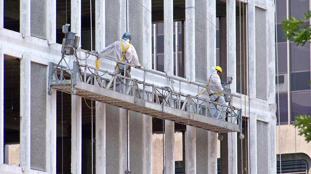 Historical photograph of workers handling raw asbestos at an industrial facility.
