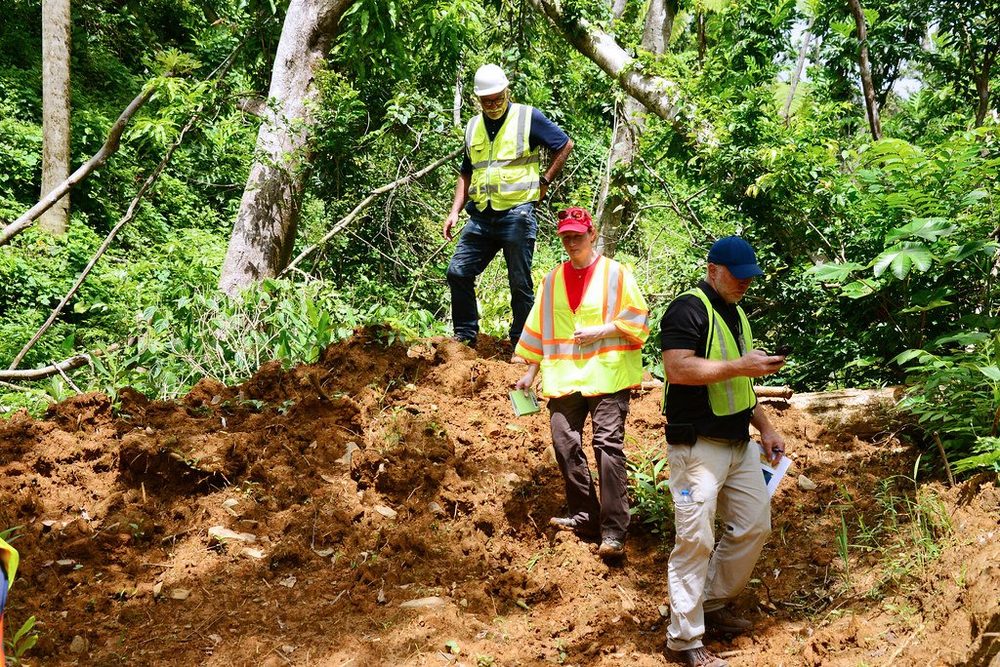 Cleanup crews work on an environmental release site, with response equipment and disturbed ground visible.